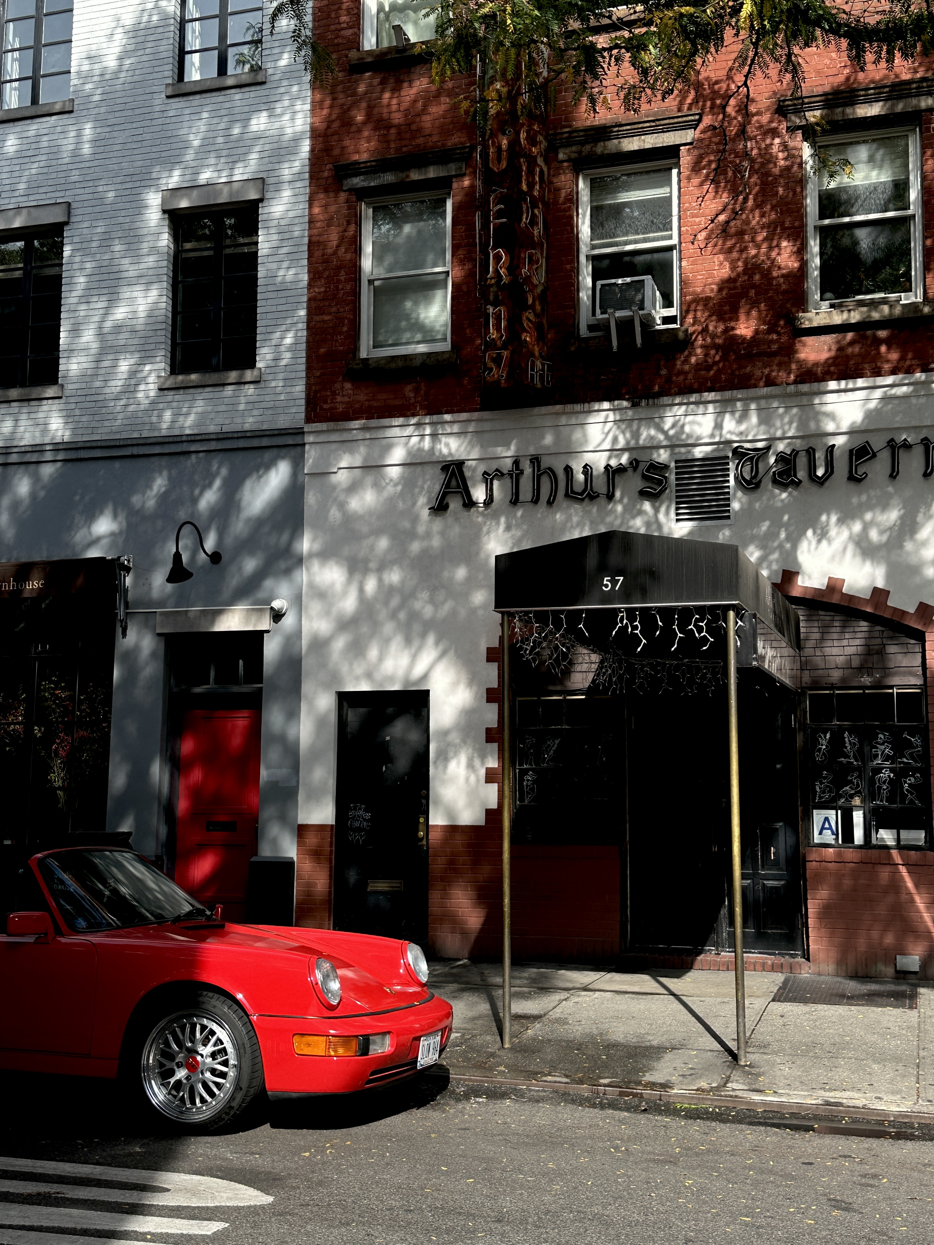 a red vintage porsche pokes through the sunlight in manhattan