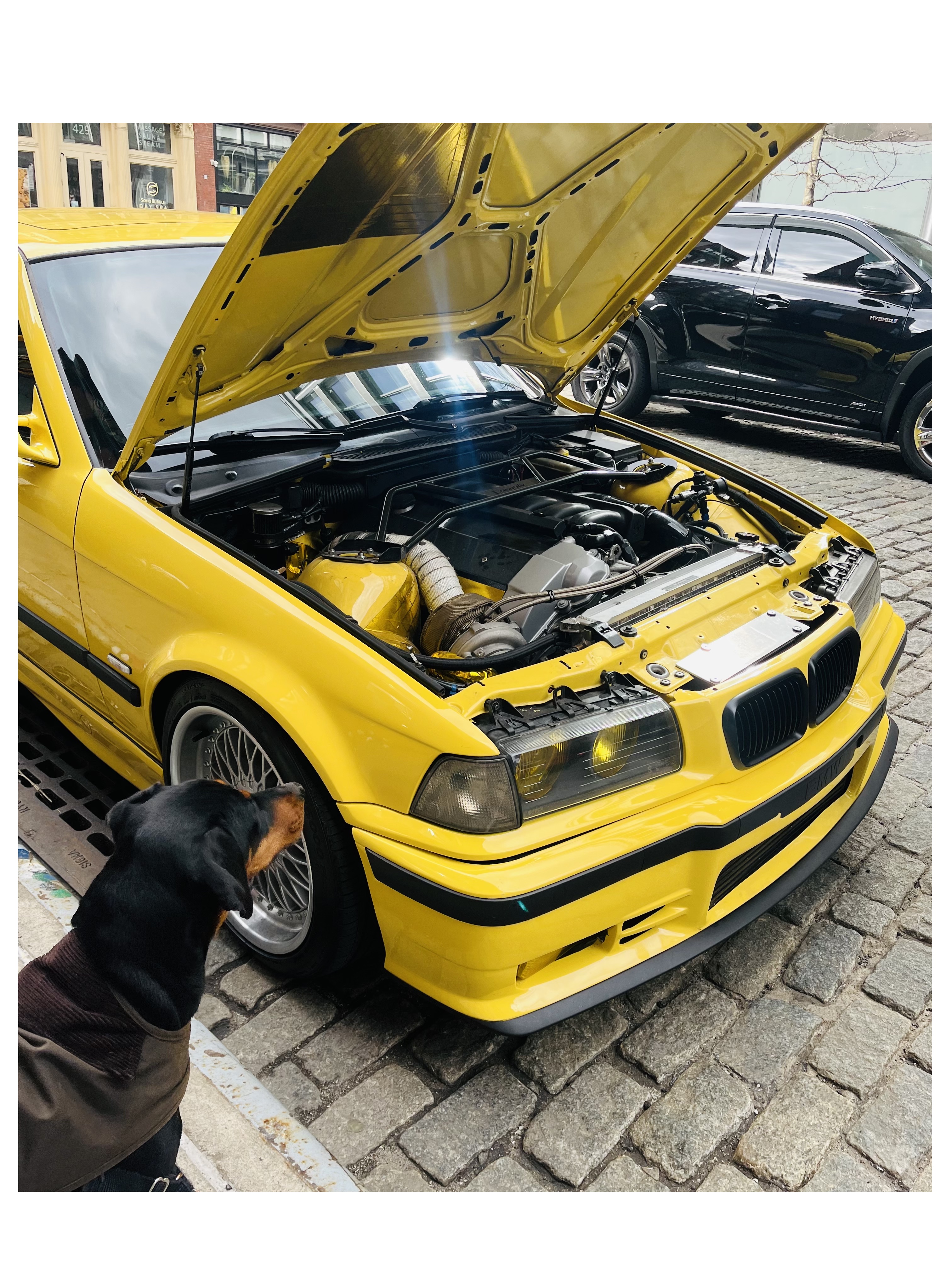 a bright yellow bmw with the engine exposed
