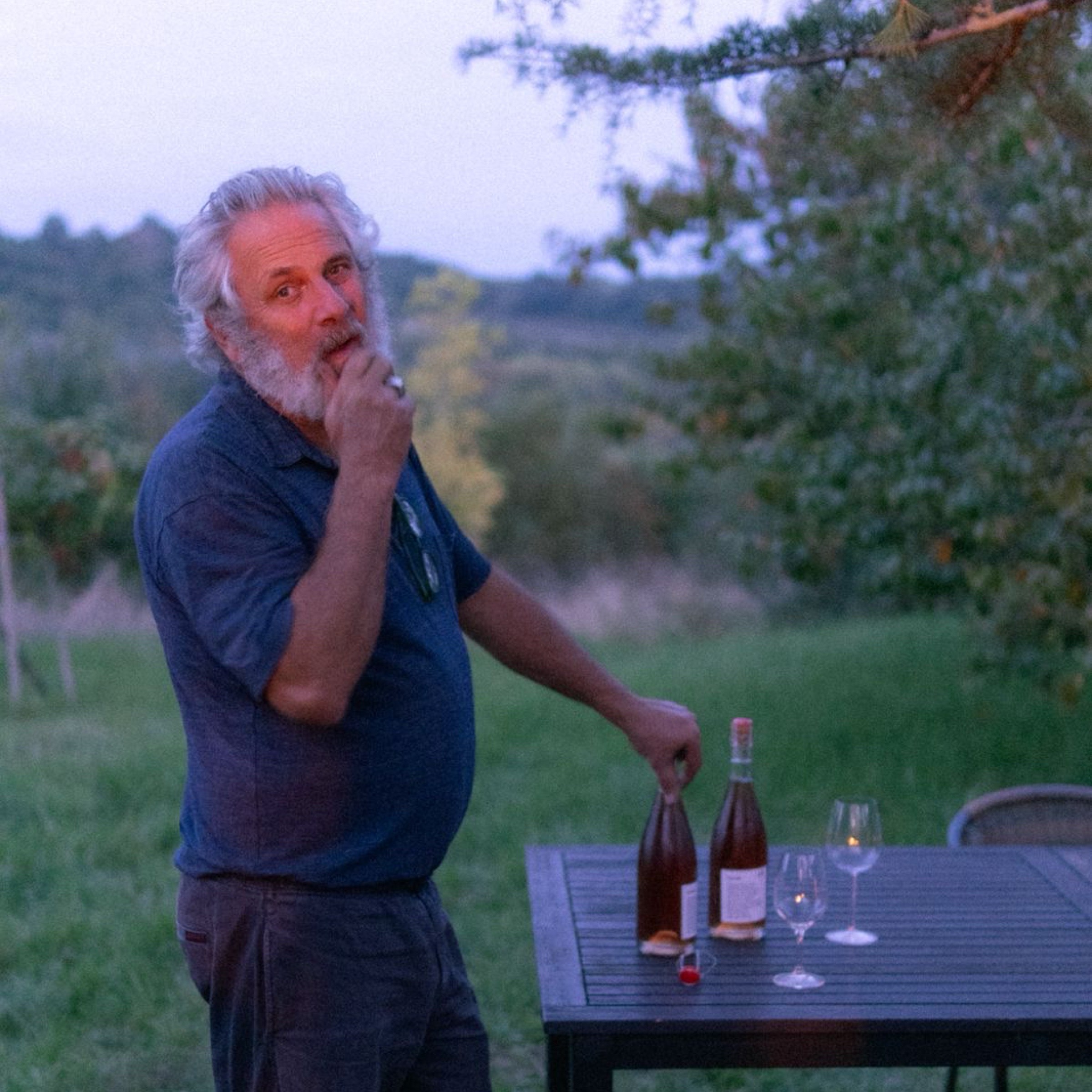 man with bottles of wine by a table
