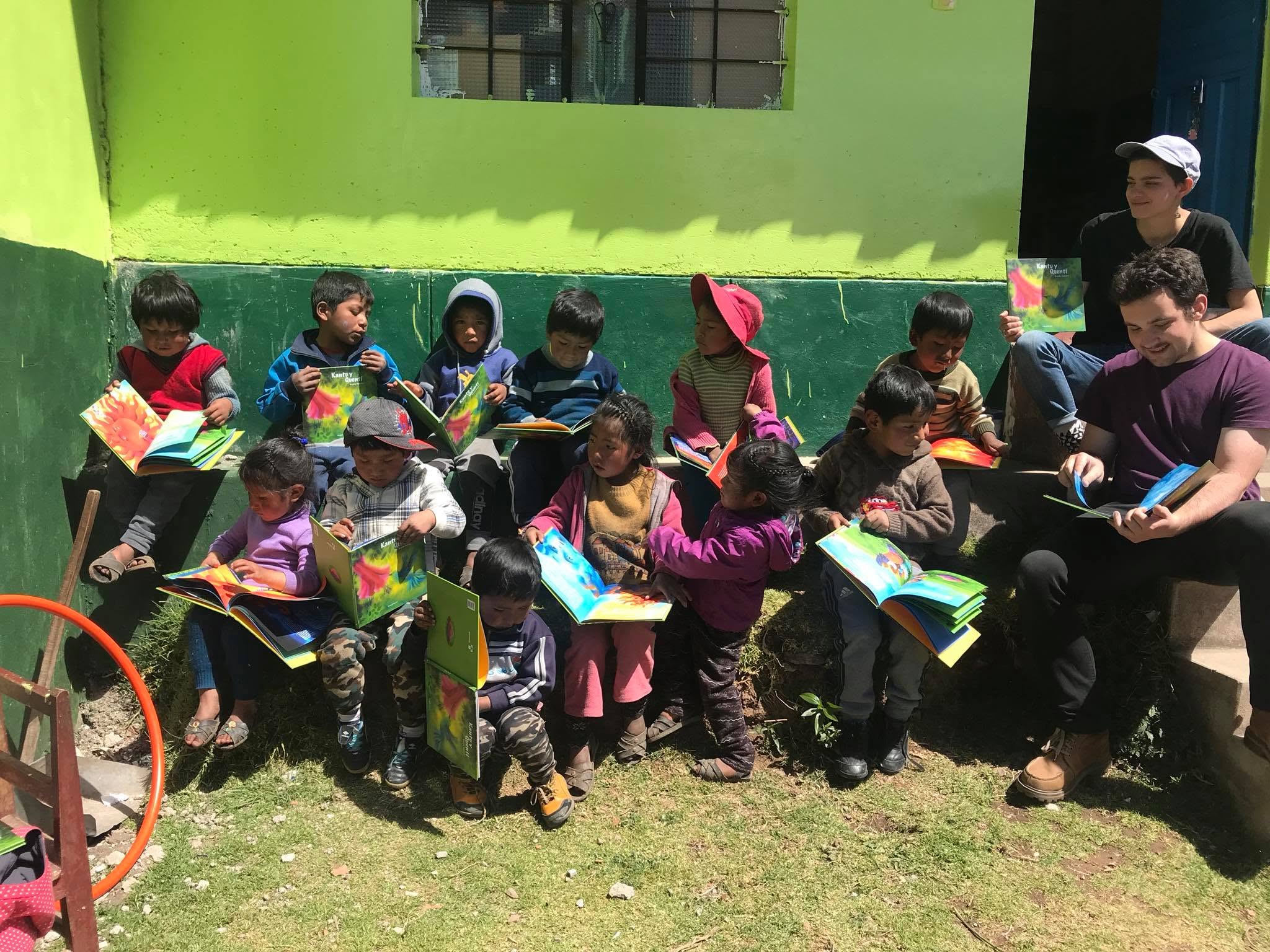 Children holding books outside a classroom